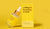 Image of yellow Absolute Collagen serum bottle propped against yellow box on a yellow background