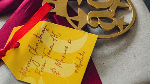 Close up photo showing a gold Absolute Collagen Christmas decoration and yellow gift tag